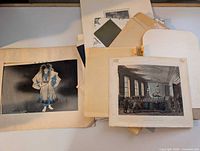 Stack of various antique prints and drawings showing different styles and subjects.