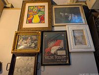 Overall view of six framed art pieces arranged together showing variety of styles and sizes