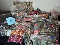Overview of mixed bead bags and a compartment box with various types and colors of beads for jewelry making