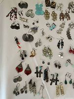 Photo showing assorted costume earrings in various styles including beaded danglers, filigree, and geometric shapes