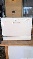 Front view of white SPT countertop dishwasher showing control panel and handle.