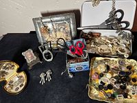 Overall view of lot on black surface showing frames, tins, dishes and scissors