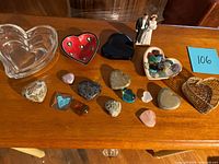Overview of various heart-shaped items including glass bowls, stones, wicker basket, and figurine on wooden surface