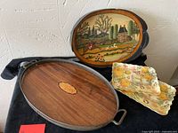 All four trays arranged on black fabric showing wood, hand-painted and acrylic trays