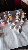 Photo showing colorful hand-painted ceramic nativity figurines displaying Mary, Joseph, Baby Jesus, wise men, shepherds, and animals.
