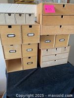 Multiple wood storage boxes stacked together showing different sizes and finishes, front view