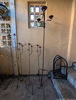 Photo showing 4 tall slender single candle holders and 1 taller stand with 3 candle holders with curved arms