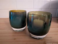 Front view of both glass tealight holders showing color gradient and clear bases