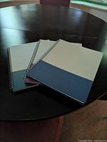 Three notebooks stacked showing two-tone covers