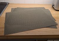 Four black/beige vinyl placemats laid flat showing overall size and quantity