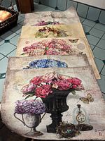 Six folded placemats laid out showing various floral designs