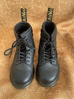 Top view of both black kids boots showing laces, size, and overall condition