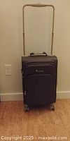 Front view of grey spinner carry-on suitcase with telescopic handle extended