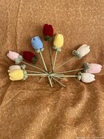Radial arrangement of all ten crocheted tulip flowers showing colours and stems