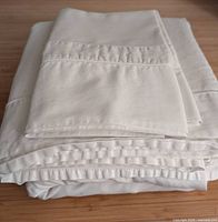 Folded sheet set showing flat sheet, fitted sheet and pillowcases stacked