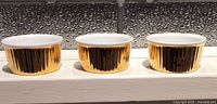 Three gold fluted ramekins front view