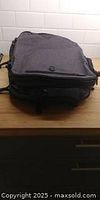 Front view of black travel backpack on countertop
