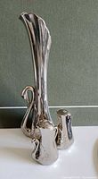 Tall silver-plated swan vase with two matching shakers front view