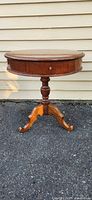 full view of round wooden pedestal side table outdoors