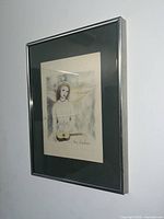 Oblique angle view of the framed etching and watercolor showing overall presentation and condition.