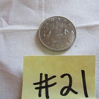 Photo of one 1969 Canadian dollar coin showing the canoe and voyageurs design with the date.