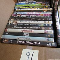 Photo showing a stack of DVD movies with titles including Horrible Bosses, Idiocracy, A Thousand Words, Love & Mercy, Bégin Nouveau, Refrain Again, and more.