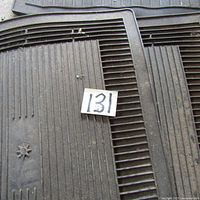 Close-up photo showing part of the rubber mat surface with visible dirt and a thin layer of dust.