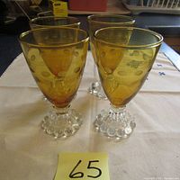 Four vintage amber Boopie glasses by Anchor Hocking, showing overall set and base detail.