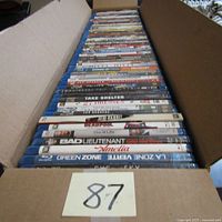 Photo showing a box with 62 Blu-ray movies stacked showing titles like Take Shelter, Deadpool, The Wife, Bad Lieutenant, and others.