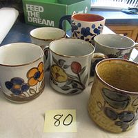 Front and top view of all 6 mugs showing colorful floral designs and minor wear.