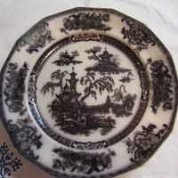 Top-down image showing full black transferware pattern on the antique ironstone plate with Asian-inspired pagoda and floral borders.