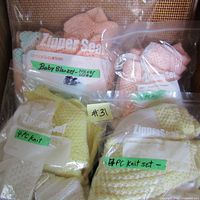 Overview of all sets and blanket in clear plastic zipper bags with handwritten labels, showing condition and colors
