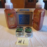 Lot contents showing two bottles of Pumpkin Pecan Waffles hand soap, two small hand sanitizers, and a boxed candle set.