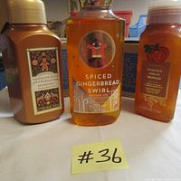 Photo shows three bath and body bottles: Cookie Butter Truffle gentle and clean foam hand soap, Spiced Gingerbread Swirl shower gel, and Pumpkin Pecan Waffles gentle and clean foam hand soap, all Bath and Body Works products in amber/orange colored bottles with sealed caps.