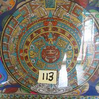 Close up of the detailed circular Aztec calendar in multi-colors, showing intricate designs and symbols inside the calendar with yellow, red, blue, and turquoise.