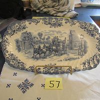 Full view of the oval ironstone plate with blue coaching scene and floral border.