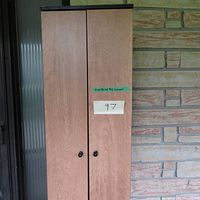 Full frontal view of the tall wooden DVD/Blu Ray cabinet showing two tall doors on top with black knobs and some light wear on surface.