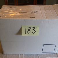 Sealed white cardboard box front with lot number sticker