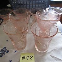 Photo showing 8 pieces of pink depression glass including creamer, sugar bowl, tumblers, and ice cream dishes.