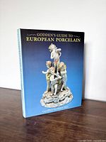 Front cover of the hardcover book showing detailed porcelain figures and title.
