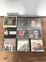 Front facing display of 9 Beethoven classical music CDs with artwork showing Beethoven portraits and classical themes on the wooden surface