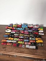 Overview photo showing all toy cars and vehicles in the lot laid out on a wooden surface.