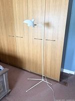 Full view of the white Serge Mouille style floor lamp with tripod base, showing height and style.