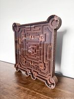 Wooden Castle Maze labyrinth game board showing maze pathways and corners shaped like castle towers, standing on a wooden surface.