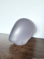 Side angle view of the solid acrylic mannequin head, showing smooth frosted surface and rounded shape.