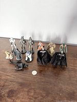 Thirteen Star Wars action figures including Darth Vader, Yoda, Boba Fett, Luke Skywalker, R2-D2, Stormtrooper and others on a wooden surface
