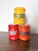 Front view showing three ceramic koozies stacked in pyramid formation with distinct colors and logos.