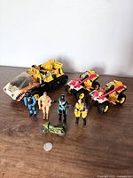 Five G.I. Joe action figures with a yellow and black tracked vehicle and two ATV style vehicles in yellow and red.