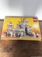 Front of the LEGO set box showing the assembled castle and minifigures with horses typical of the LEGO Castle 6080 set.