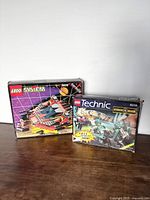 Photo of two vintage LEGO sets: System 6939 in box and Technic 8239 Cyber Slam in box with visible wear.